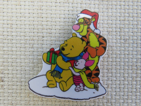 First view of Pooh, Tigger and Piglet opening a Christmas gift minder.