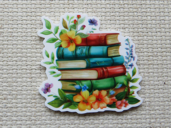 First view of a colorful stack of six books with yellow flowers and pretty leaves minder.