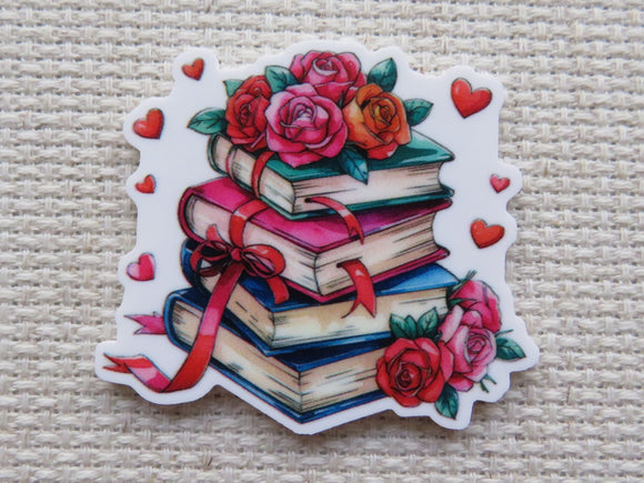 First view of a stack of four books surrounded by red hearts and red roses minder.