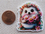 Floral hedgehog with pink daisies with penny for scale.