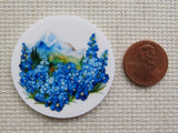 Second  view of circle minder with blue flowers along the front and a mountain in the background.