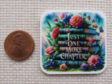 This square shaped minder has a stack of books surrounded by flowers and butterflies and the words "Just one more chapter".