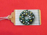Wreath with silver, green, and gold colored ornaments gift tag.