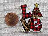 Minder with 'LOVE' design featuring plaid and leopard print patterns, next to a penny for scale.