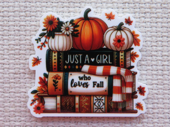 Minder with pumpkins, books, and a scarf.