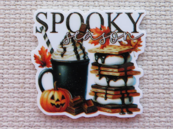 Minder with Halloween-themed elements including a mug, a tower of smores, and pumpkin.