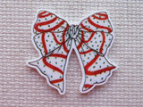 Decorative bow minder with red and white pattern on a textured beige background
