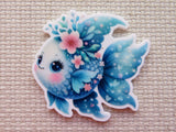 Decorative minder of a blue fish with floral elements on a textured beige background