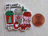 Minder with coffee cups and text 'All I want for Christmas is more coffee' next to a penny on a textured surface.