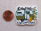 Minder with a camper design and text 'Camping is my happy place' next to a penny on a textured surface.