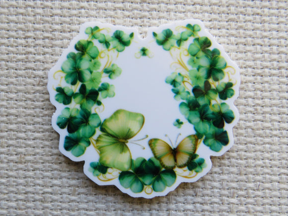 Minder with green clover leaves and butterflies on a textured beige background