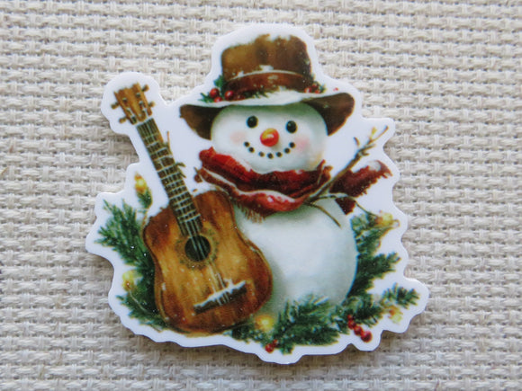 Minder of a snowman holding a guitar on a textured beige background
