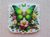 Decorative minder with green butterfly and flowers on a textured beige background