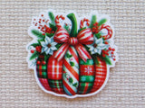 Decorative minder with Christmas-themed design featuring candy canes, a bow, and festive elements on a textured beige background.