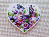 Heart-shaped minder with butterflies and flowers on a textured surface
