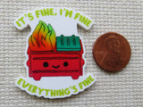 Minder with a fire and text 'It's fine, I'm fine, everything's fine' next to a penny on a textured surface.