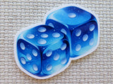 Two blue dice with white dots minder on a textured beige surface
