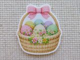 Minder of a wicker basket with Easter eggs and flowers on a textured fabric background