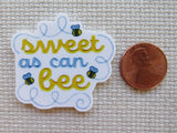 Minder with 'sweet as can bee' text and bees, next to a penny for scale.