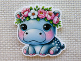 Cartoon hippo with floral crown minder on a textured beige background