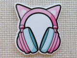 Minder of pink headphones with cat ears on a textured beige background
