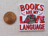 Minder with 'Books are my love language' text and books illustration next to a penny for size comparison on a textured background.