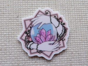 First view of Hands Holding a Crystal Ball Needle Minder.