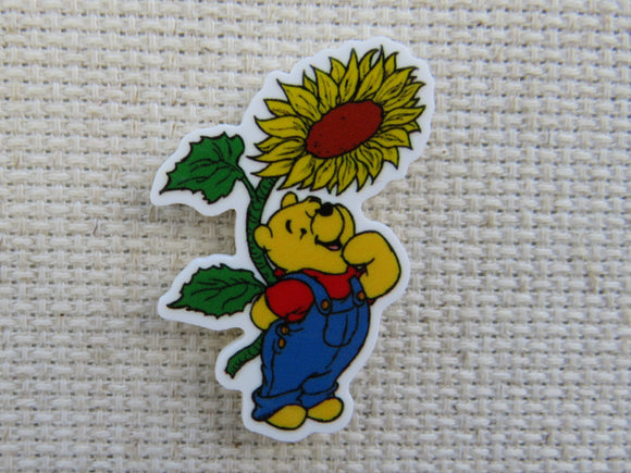 First view of Pooh is looking up at a sunflower in amazement. minder.