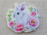 Minder of a rabbit surrounded by pink flowers on a textured beige background