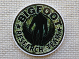 Round minder with Bigfoot Research Team text and silhouette on a textured background