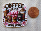Minder with coffee-themed design and a penny for scale on a textured surface