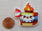 Minder of a cartoon marshmallow character with a campfire on a textured surface next to a penny.