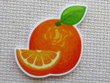 Minder of an orange with a slice on a textured beige background