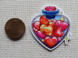 Second view of A Heart Shaped Bottle of Hearts Needle Minder.