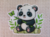 A minder featuring a cute cartoon panda sitting on a bamboo log and holding a bamboo shoot, with green leaves and a butterfly around it, shown on a textured beige fabric background.