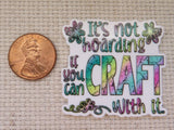 Colorful minder with text 'It's not hoarding if you can craft with it' next to a penny on a textured background