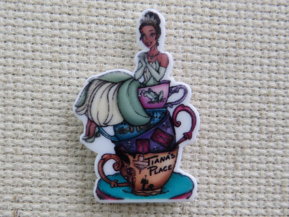 First view of Tiana Sitting on Top of a Stack of Teacups Needle Minder.