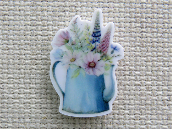 First view of Blue watering can holding fresh picked flowers needle minder.