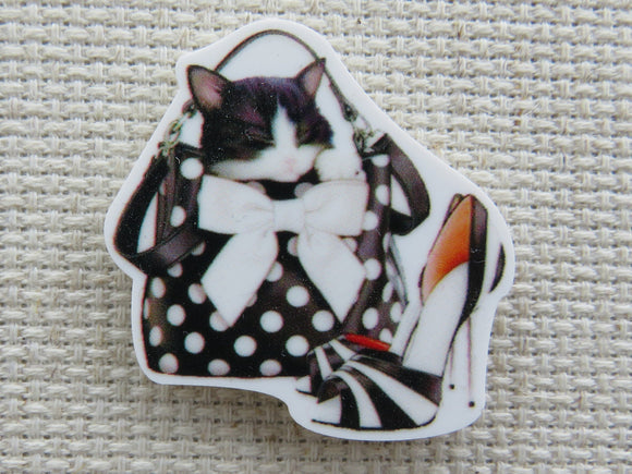 First view of Adorable kitten in a black and white polka dot purse with a stiletto heeled shoe next to it minder.