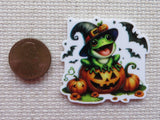 Second view of Cute frog with a witch's hat sitting on top of a jack-o-lantern with bats flying around him minder.