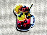 A minder featuring a colorful iced mason jar drink with berries, citrus slices, and a striped straw, placed on a textured beige fabric background.
