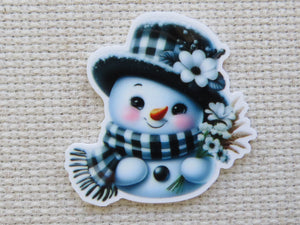 First view of Black and white snowman with a checkered hat and scarf with white daisy flowers minder.