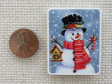 Second view of Red scarf wearing snowman with a birdhouse in one hand and a candy cane in the other minder.