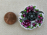 Second view of A pair of moons and pretty flowers surround this pentagram minder.