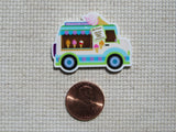 Colorful ice cream truck minder next to a penny.