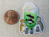 Second view of A couple of tabby cats and baby penguins are watching mom and dad penguin swim inside a frothy green drink minder.