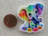 Second view of adorable elephant looks like someone splashed him with all of the colors of the rainbow and then laid flowers at his feet minder.