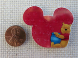 Second view of Pooh Bear Sitting Next to Red Mouse Ears Needle Minder.