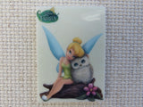 First view of Tinkerbell is sitting on a log with an owl needle minder.