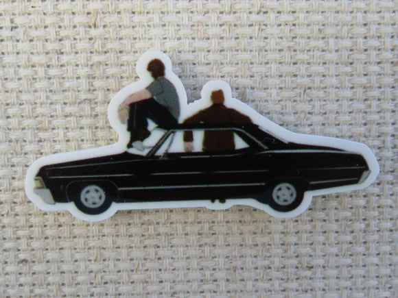 First view of A Couple of Winchester Boys Sitting on a Black Car Needle Minder.